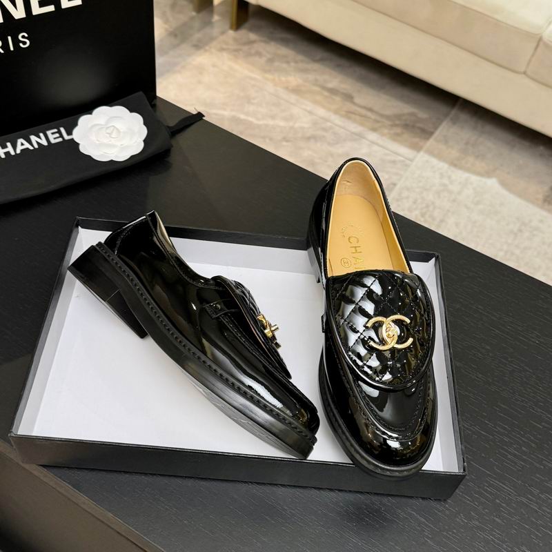 Chanel black patent leather quilted CC loafers with gold-tone hardware, displayed in black Chanel box