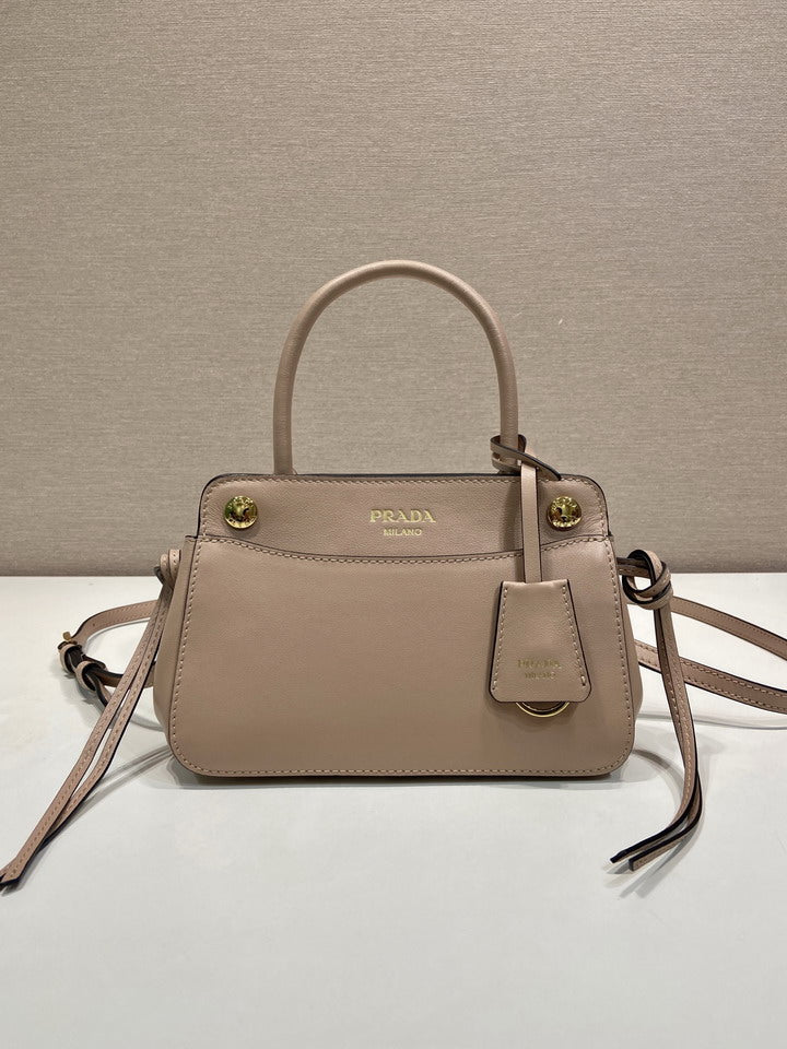 Prada Carry Handbag in powder pink fine-grain leather with gold-tone hardware and crossbody strap